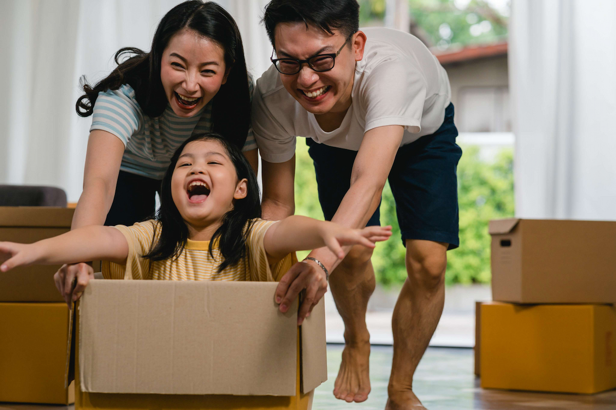 happy-asian-young-family-having-fun-laughing-moving-into-new-home-japanese-parents-mother-father-smiling-helping-excited-little-girl-riding-sitting-cardboard-box-new-property-relocation (2)