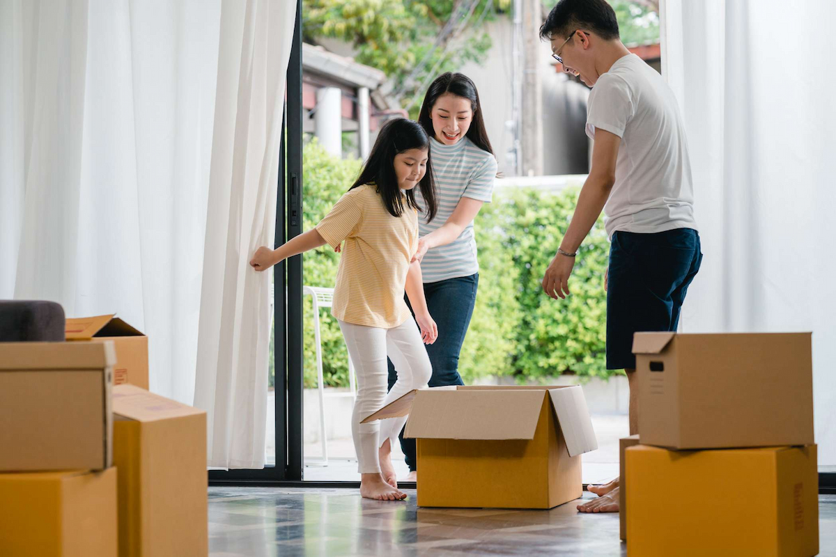 happy-asian-young-family-having-fun-laughing-moving-into-new-home-japanese-parents-mother-father-smiling-helping-excited-little-girl-riding-sitting-cardboard-box-new-property-relocation